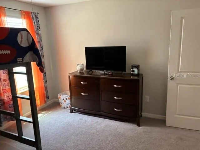 a bed sitting in a bedroom next to a window