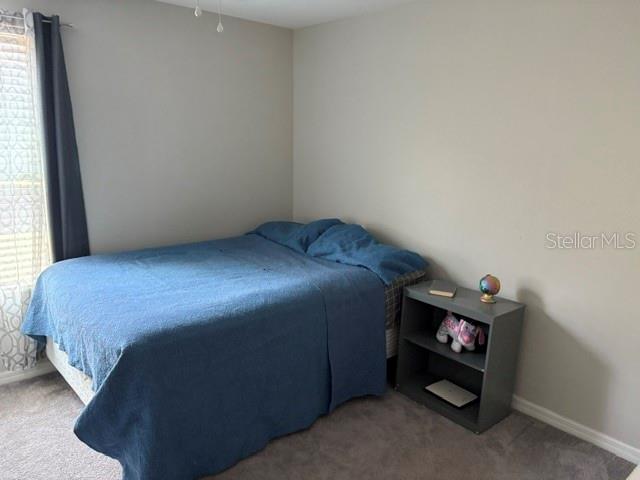 9616 Lemon Drop Loop Sun City Center, FL 33573 - Photo 41 of 48 a bed sitting in a bedroom next to a window