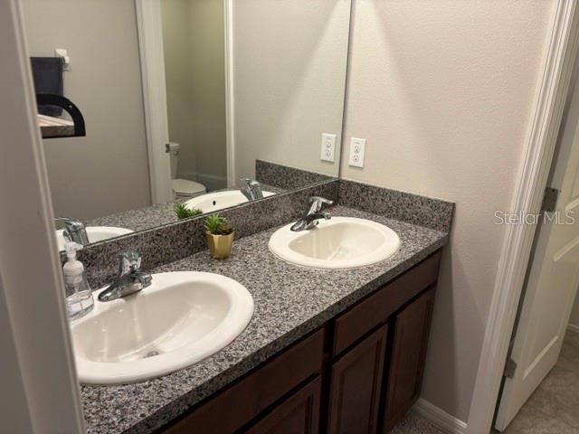 9616 Lemon Drop Loop Sun City Center, FL 33573 - Photo 42 of 48 a bathroom with a granite countertop sink and a mirror