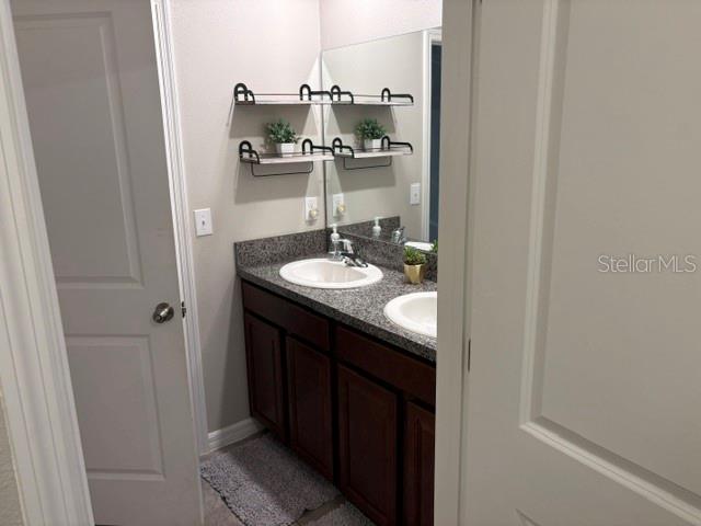 9616 Lemon Drop Loop Sun City Center, FL 33573 - Photo 43 of 48 a bathroom with a granite countertop sink and a mirror