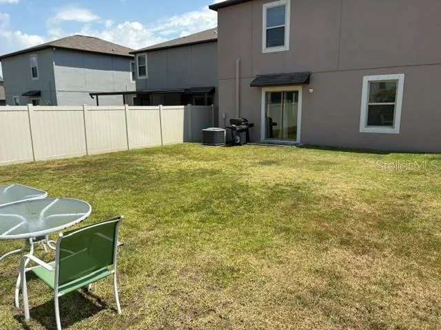 a backyard of a house with table and chairs