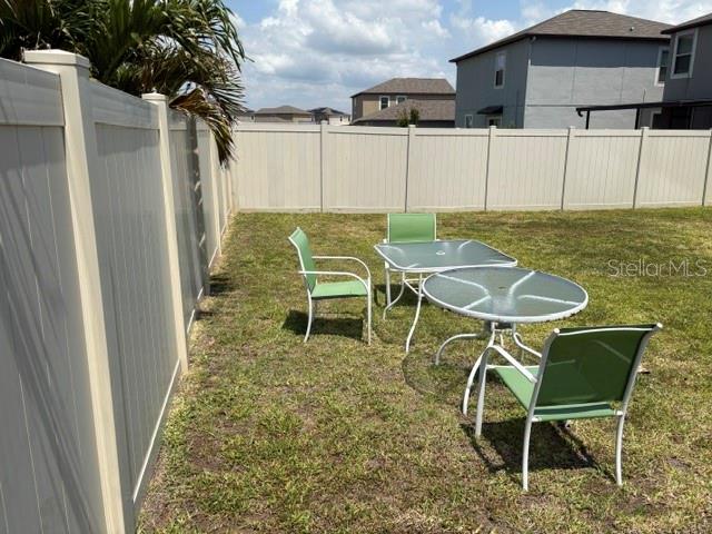 9616 Lemon Drop Loop Sun City Center, FL 33573 - Photo 45 of 48 a backyard of a house with table and chairs