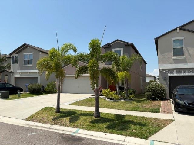 9616 Lemon Drop Loop Sun City Center, FL 33573 - Photo 7 of 48 a front view of a house with garden