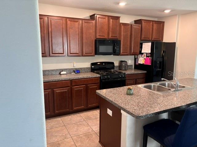 9616 Lemon Drop Loop Sun City Center, FL 33573 - Photo 10 of 48 a kitchen with stainless steel appliances granite countertop a stove refrigerator and microwave