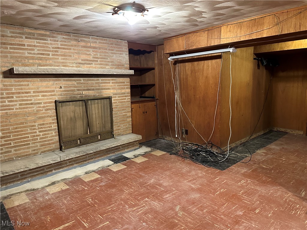 15892 Fenemore Road Cleveland, OH 44112 - Photo 42 of 48 Basement with a fireplace and wooden walls