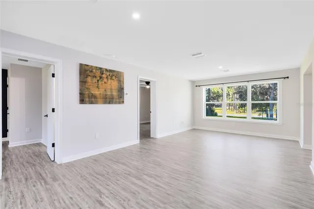 an empty room with window and wooden floor