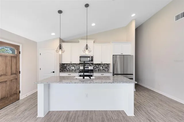 a view of kitchen with living room and stainless steel appliances