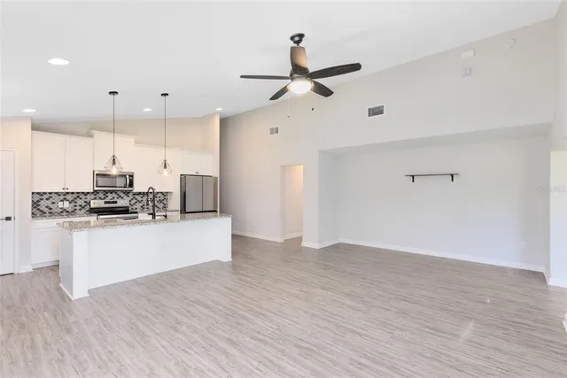 a view of kitchen with stainless steel appliances refrigerator stove microwave and cabinets