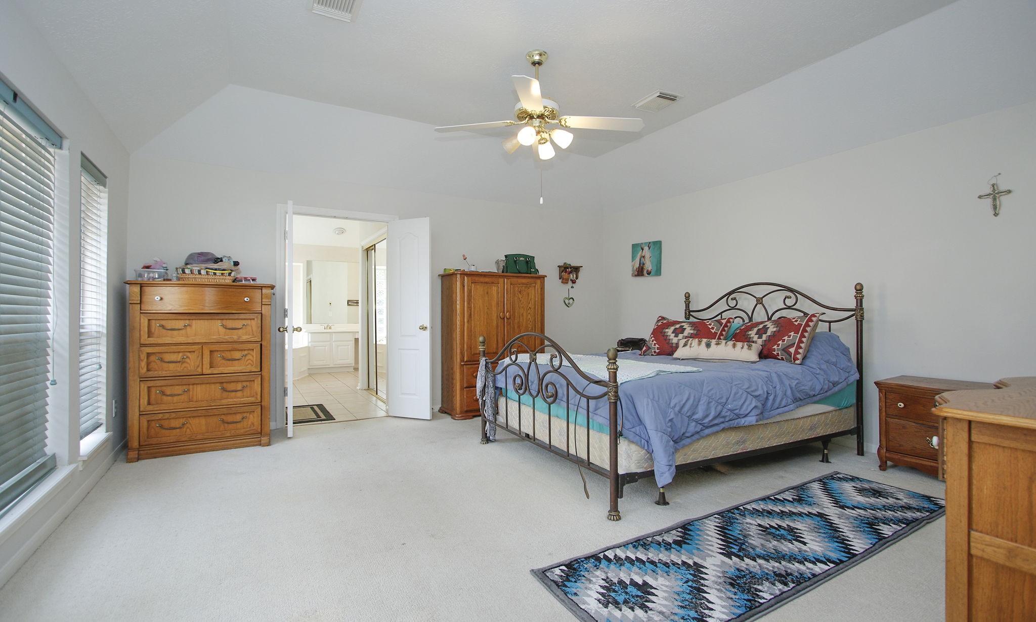 20206 Treetop Lane Spring, TX 77388 - Photo 22 of 42 a bedroom with a bed and a chandelier