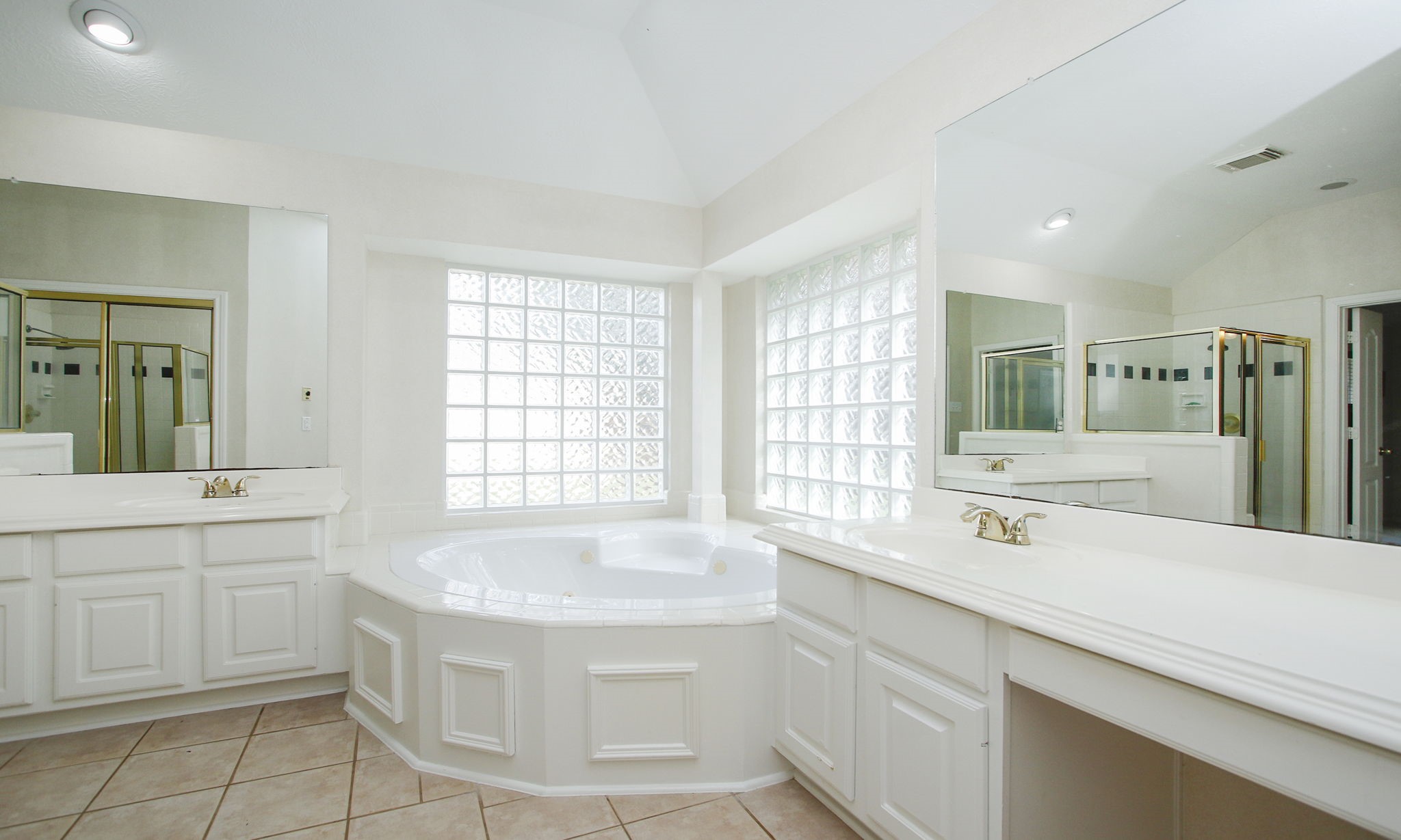 20206 Treetop Lane Spring, TX 77388 - Photo 26 of 42 a spacious bathroom with a double vanity sink a mirror and a bathtub