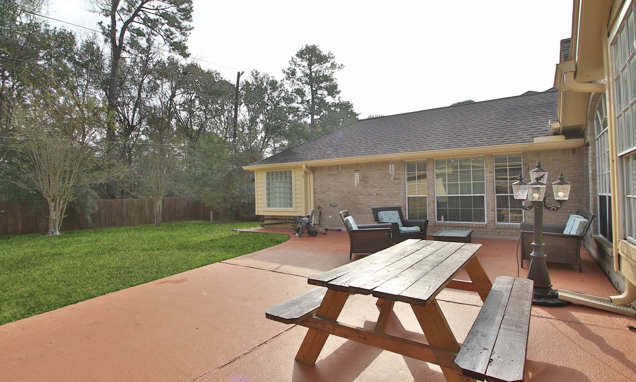 20206 Treetop Lane Spring, TX 77388 - Photo 34 of 42 a view of a backyard with table and chairs and a barbeque with potted plants