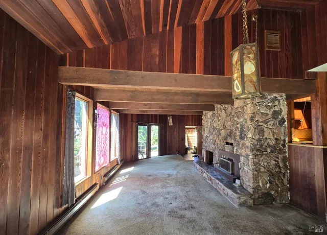 a view of an empty room with a fireplace and a window