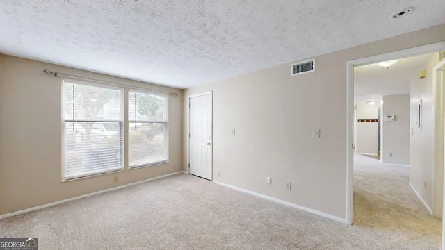 an empty room with windows and closet