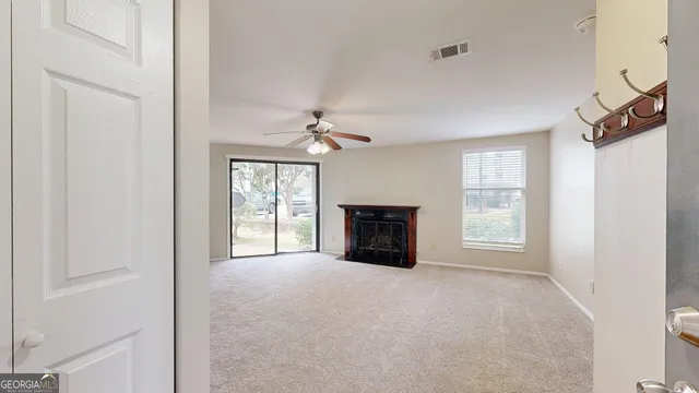 a view of an empty room with a fireplace and a window