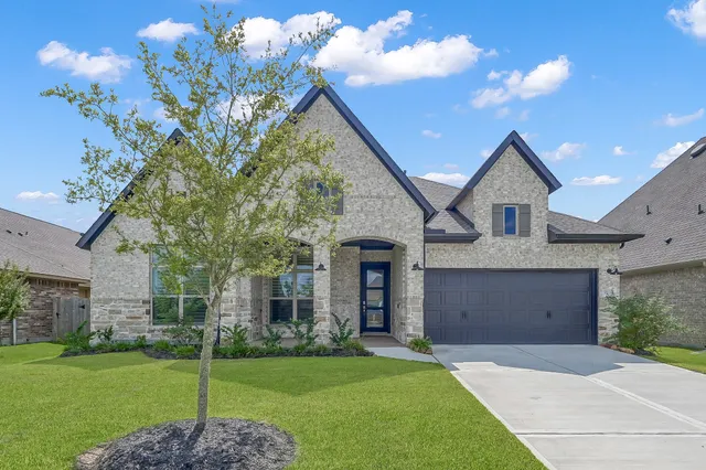 a front view of a house with a garden and yard
