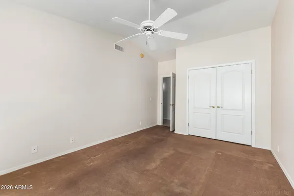 an empty room with fan and windows