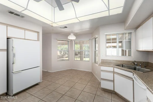 a kitchen with a refrigerator a stove cabinets and a window