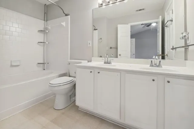 a bathroom with a double vanity sink toilet and shower