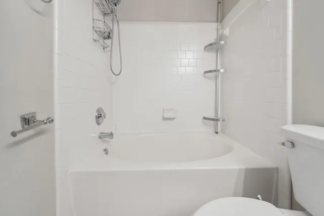 a white bath tub sitting next to a white toilet