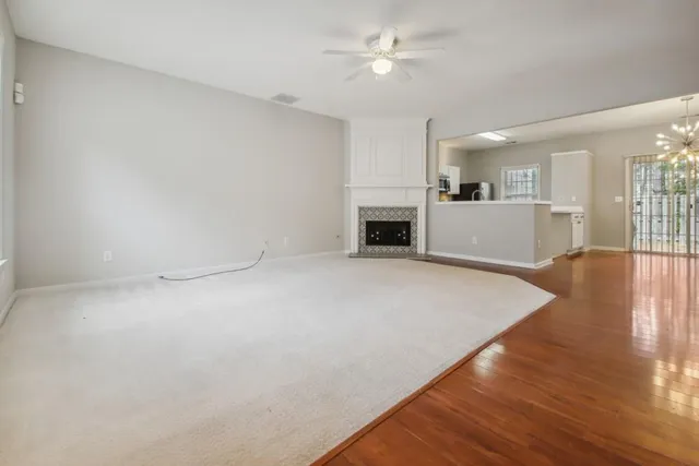 a view of empty room with wooden floor and fireplace