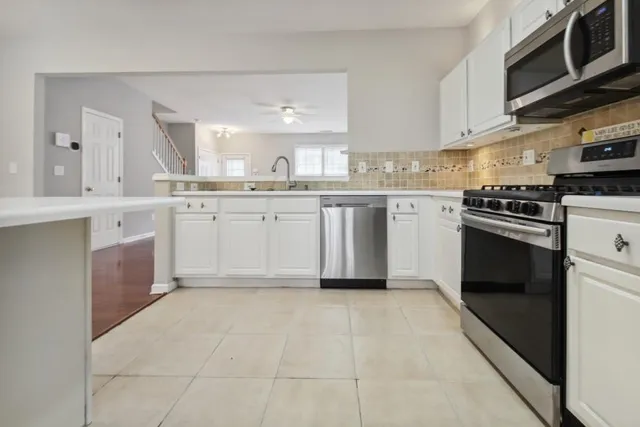 a kitchen with stainless steel appliances granite countertop a stove a sink and a microwave