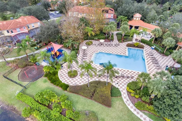 an aerial view of a house with a yard and large trees