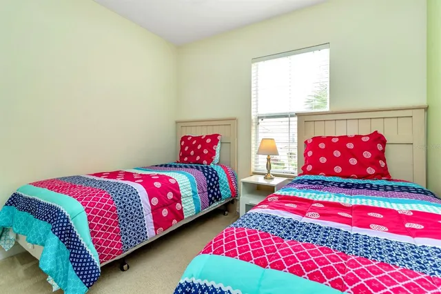 a bedroom with a two beds and a lamp