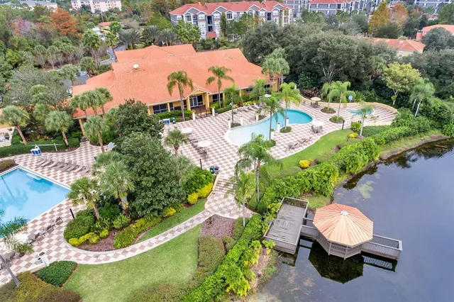 an aerial view of a house with a yard and lake