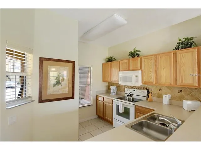 a kitchen with stainless steel appliances a stove a sink and white cabinets
