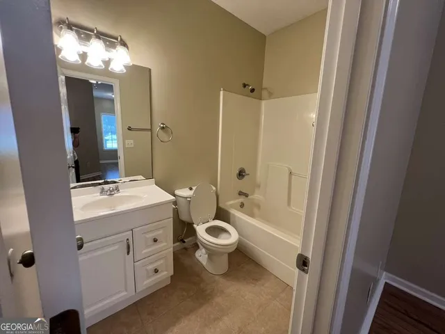 a bathroom with a double vanity sink toilet mirror and shower