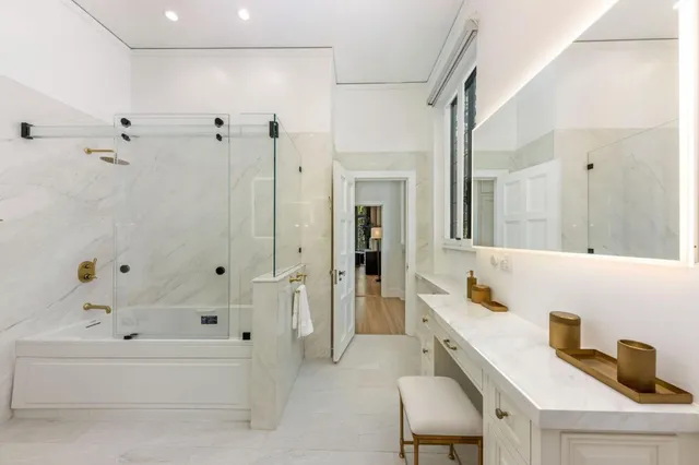 a bathroom with a double vanity sink and mirror with shower