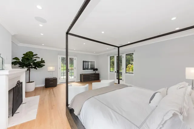 a bedroom with a bed potted plant and a fireplace