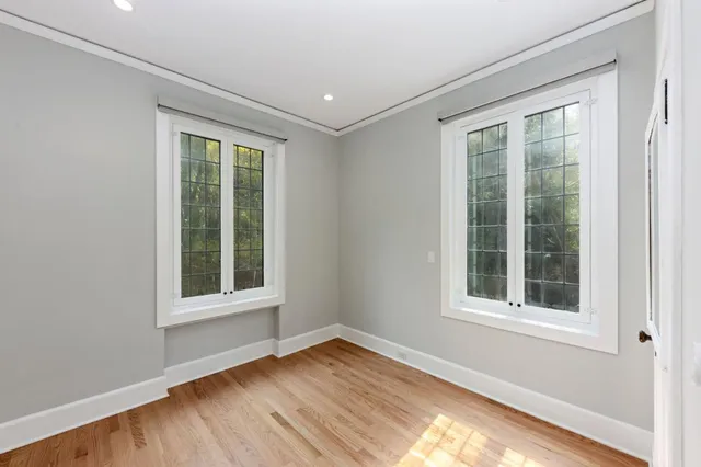 a kitchen with white cabinets a sink and a stove with wooden floor