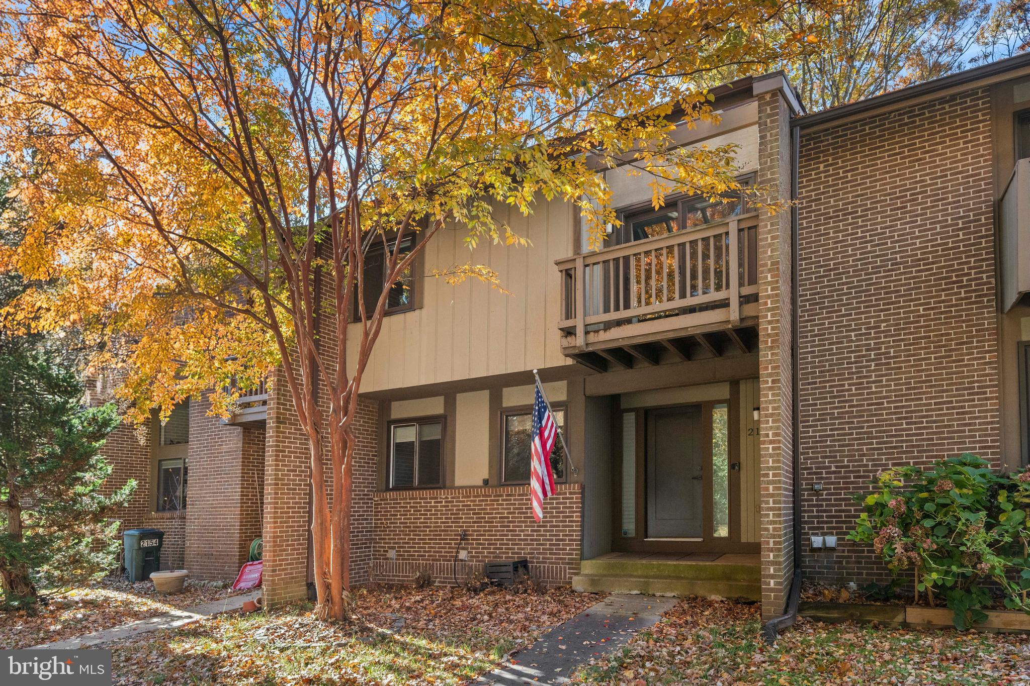 a front view of a house with a tree