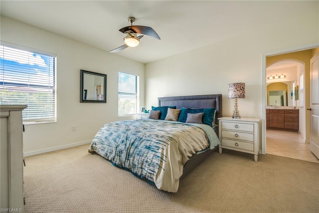1308 Kendari Terrace Naples, FL 34113 - Photo 13 of 21 Bedroom with light carpet, a ceiling fan, connected bathroom, and arched walkways