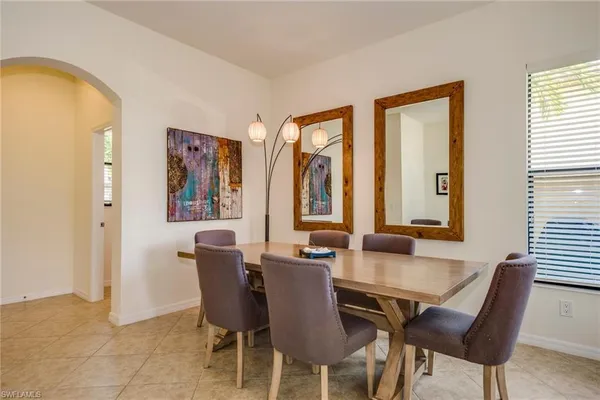 a dining room with furniture and large windows
