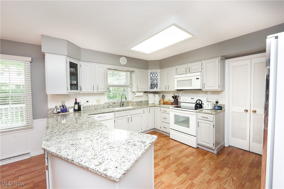 817 Rickel Circle Akron, OH 44333 - Photo 11 of 49 Kitchen with white appliances, a sink, a peninsula, and light grey cabinets