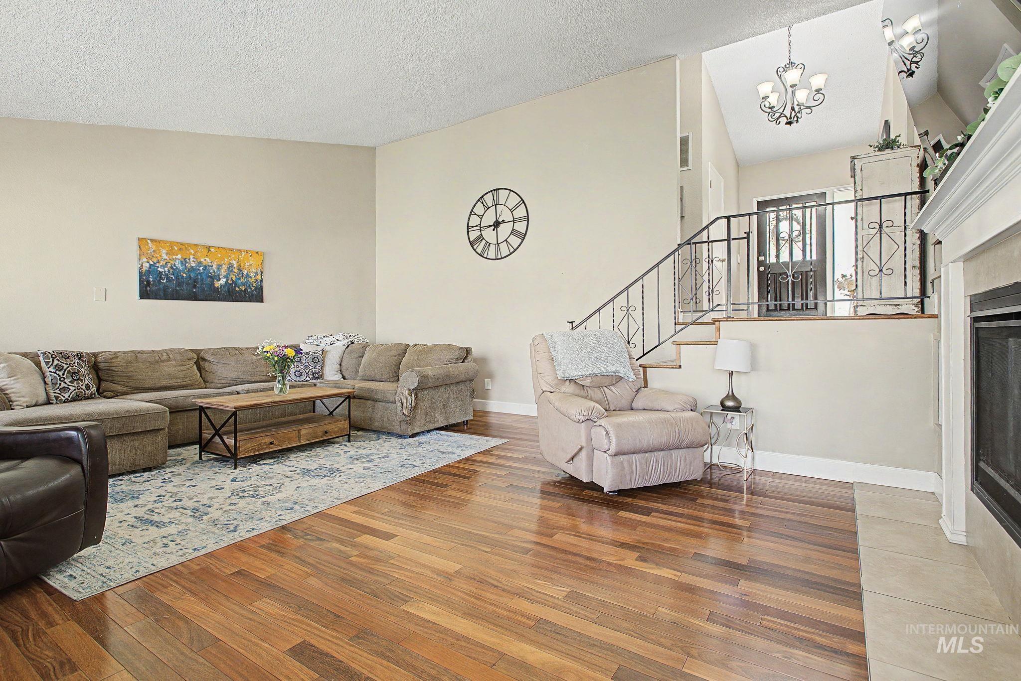 501 Karin Avenue Lewiston, ID 83501 - Photo 17 of 50 Living area with hardwood / wood-style flooring, lofted ceiling, a fireplace, and suspended lighting