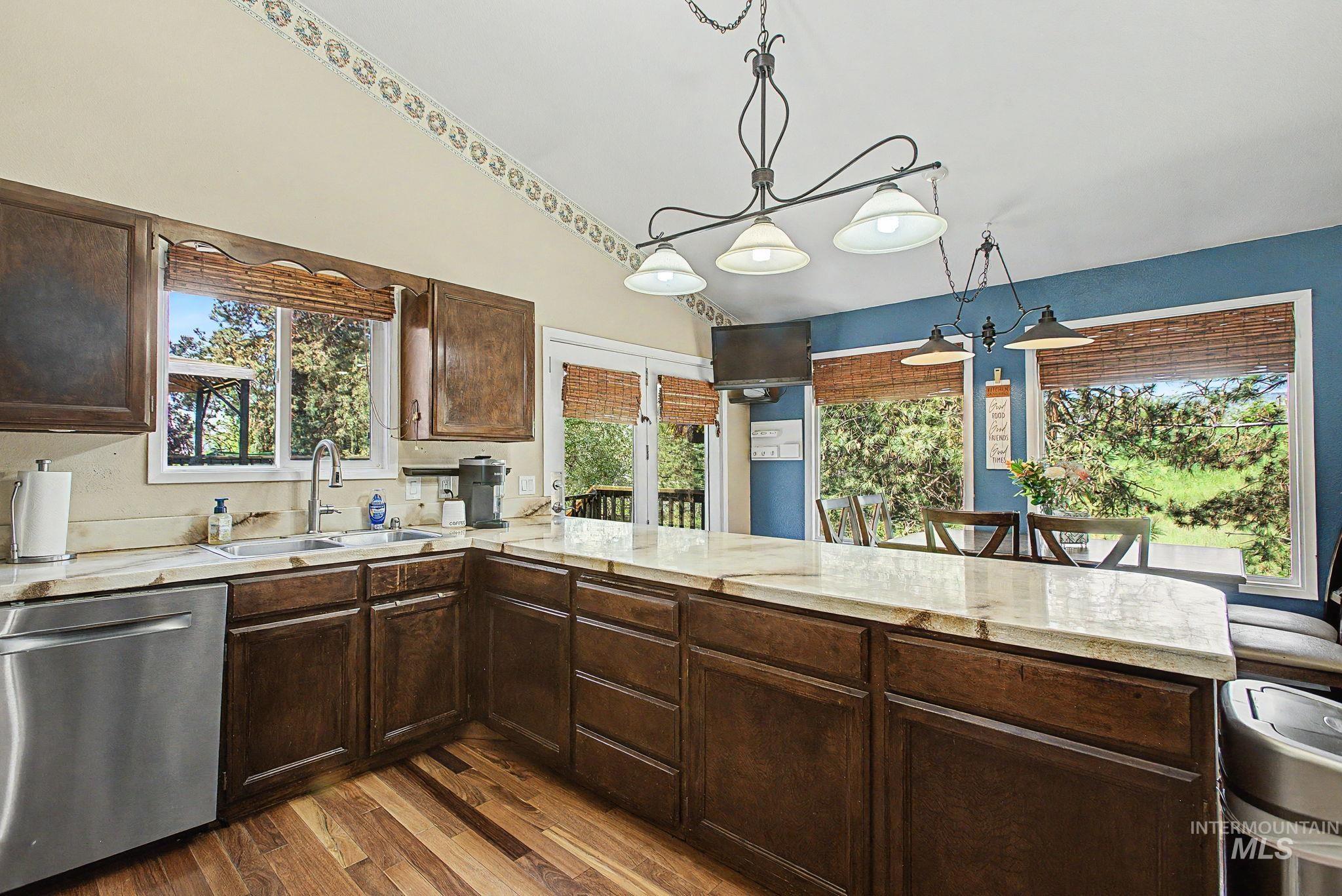 501 Karin Avenue Lewiston, ID 83501 - Photo 21 of 50 Kitchen featuring dishwasher, dark wood finish cabinets, a peninsula, dark wood finished floors, and vaulted ceiling