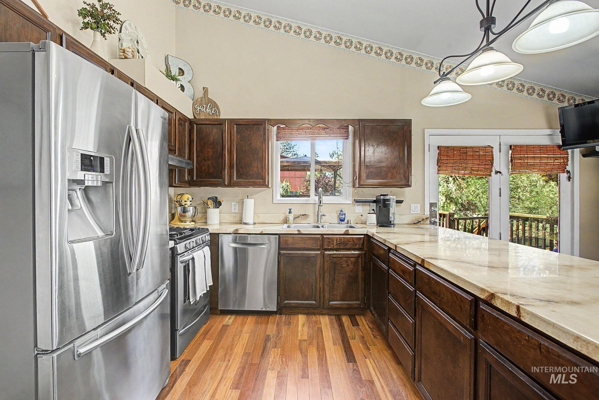 501 Karin Avenue Lewiston, ID 83501 - Photo 23 of 50 Kitchen with stainless steel appliances, dark wood finish cabinets, dark wood finished floors, and hanging light fixtures