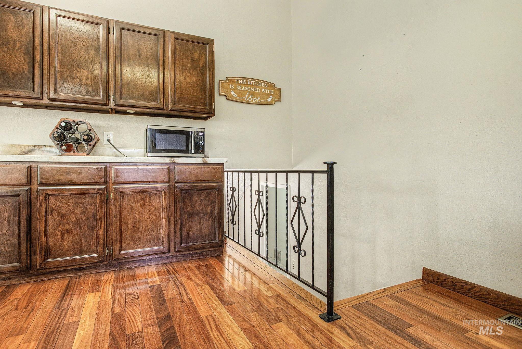 501 Karin Avenue Lewiston, ID 83501 - Photo 25 of 50 Kitchen featuring light countertops, light wood-style floors, stainless steel microwave, and dark wood finish cabinets