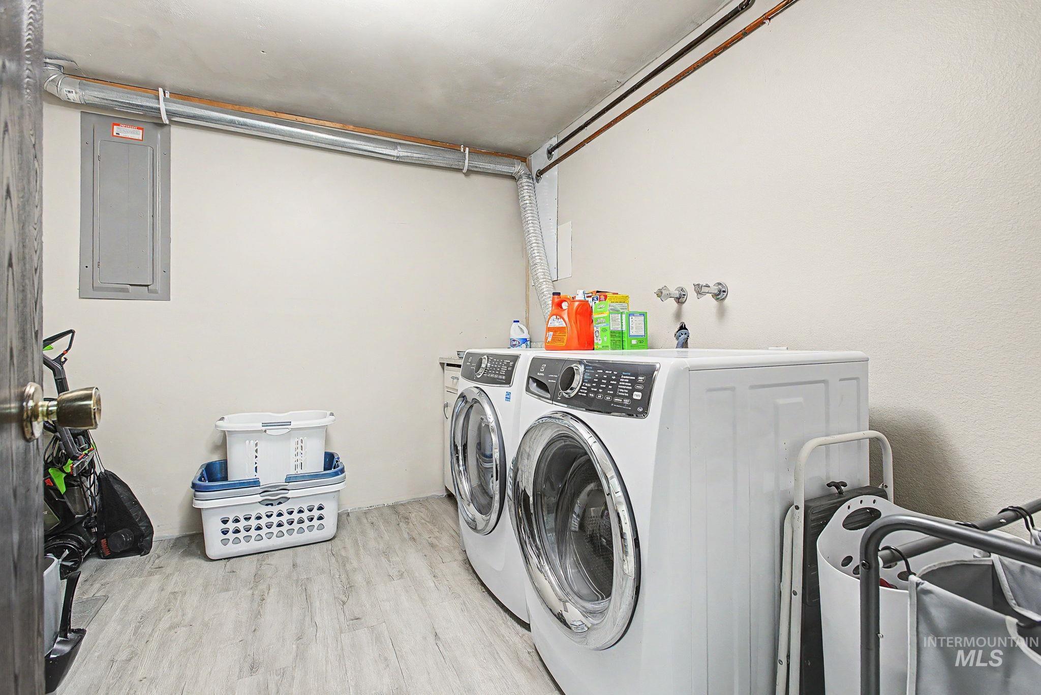 501 Karin Avenue Lewiston, ID 83501 - Photo 31 of 50 Laundry area featuring electric panel, light wood-style flooring, and washer and dryer