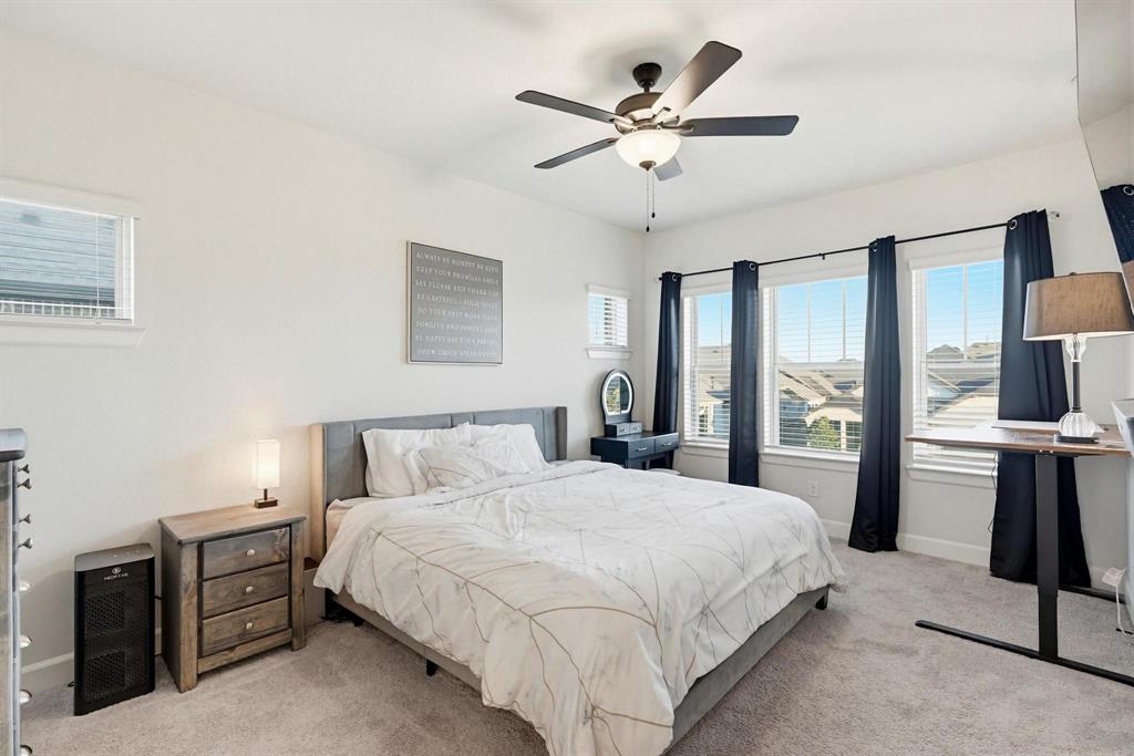 9341 Loggerhead Way Fort Worth, TX 76118 - Photo 20 of 35 Carpeted bedroom featuring multiple windows, a ceiling fan with integrated lighting, and neutral wall tones