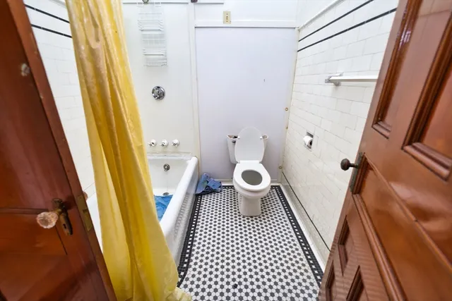 an empty room with a fireplace fan and windows