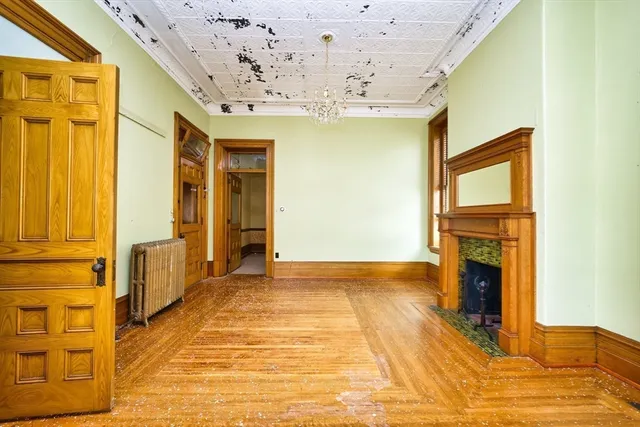 a view of an empty room with a fireplace and a window