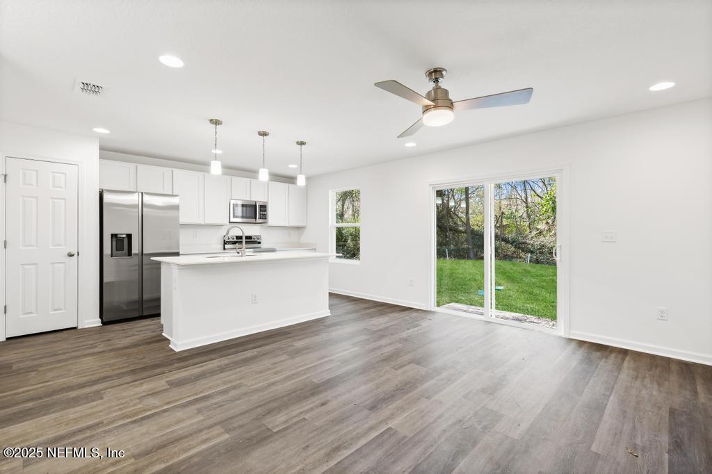 7845 Pipit Avenue Jacksonville, FL 32219 - Photo 13 of 38 a view of kitchen with refrigerator and wooden floor