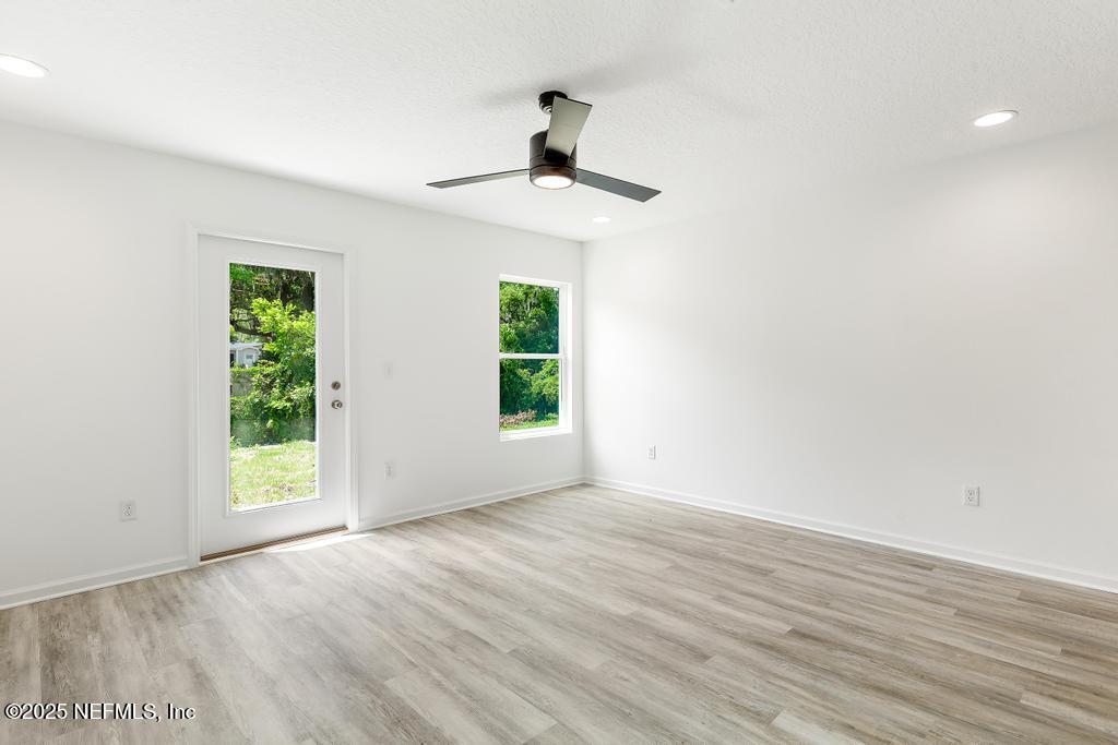 7845 Pipit Avenue Jacksonville, FL 32219 - Photo 17 of 38 a view of an empty room with wooden floor and a window