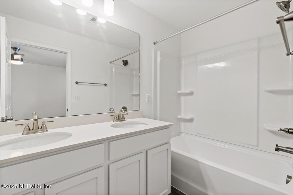7845 Pipit Avenue Jacksonville, FL 32219 - Photo 20 of 38 a bathroom with a sink double vanity granite tub shower and a mirror