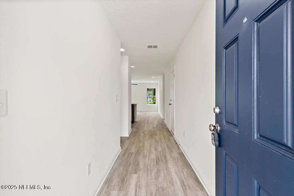 7845 Pipit Avenue Jacksonville, FL 32219 - Photo 7 of 38 a view of a hallway with wooden floor