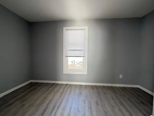a view of a room with wooden floor and window